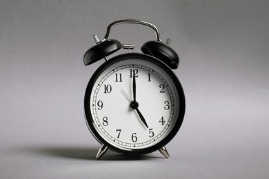 Photo of One black alarm clock on grey background