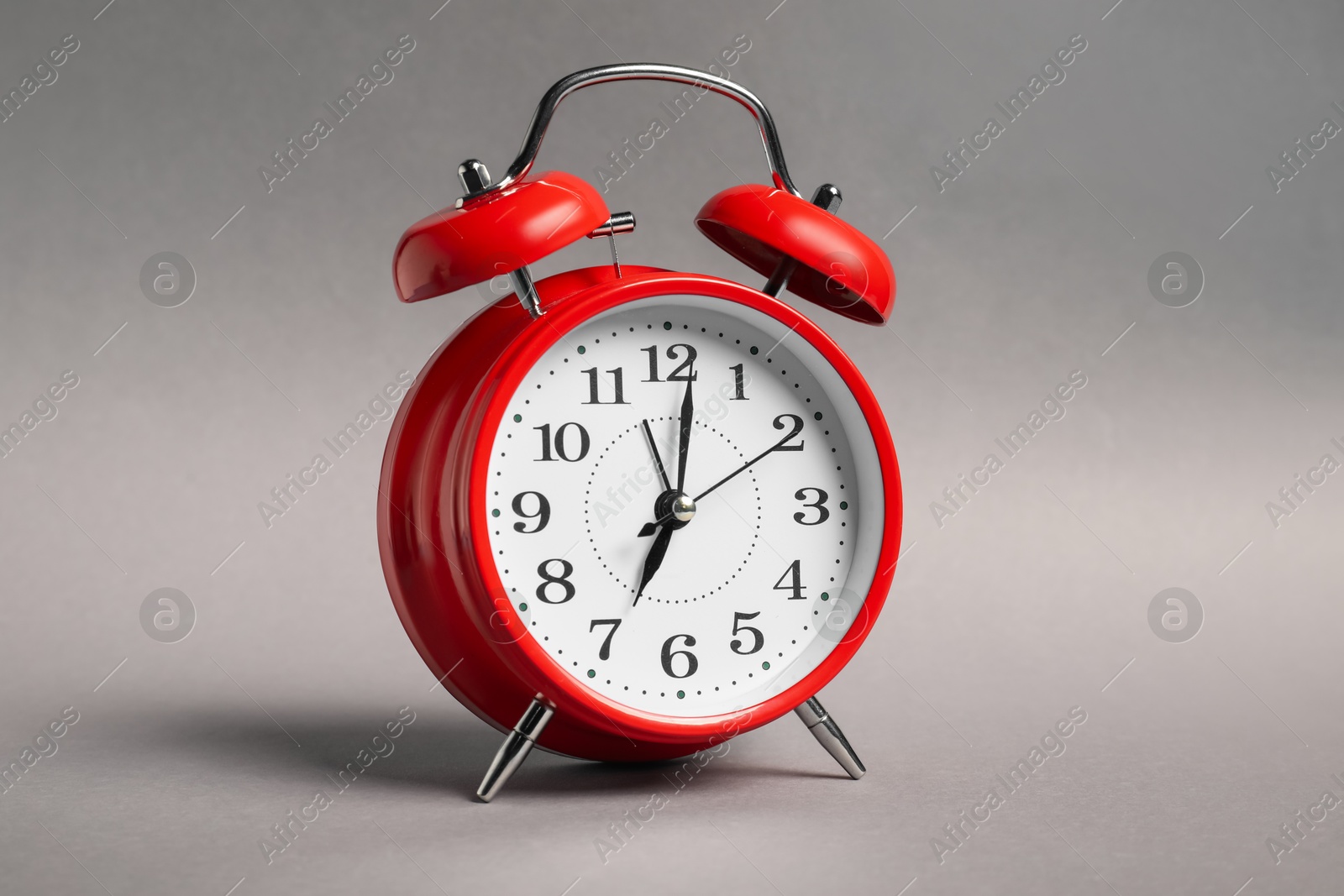 Photo of One red alarm clock on grey background