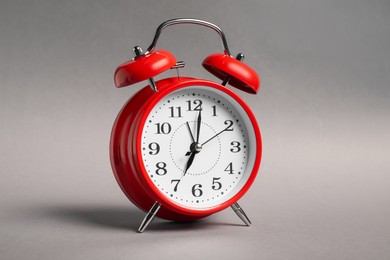 Photo of One red alarm clock on grey background