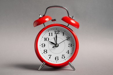 Photo of One red alarm clock on grey background