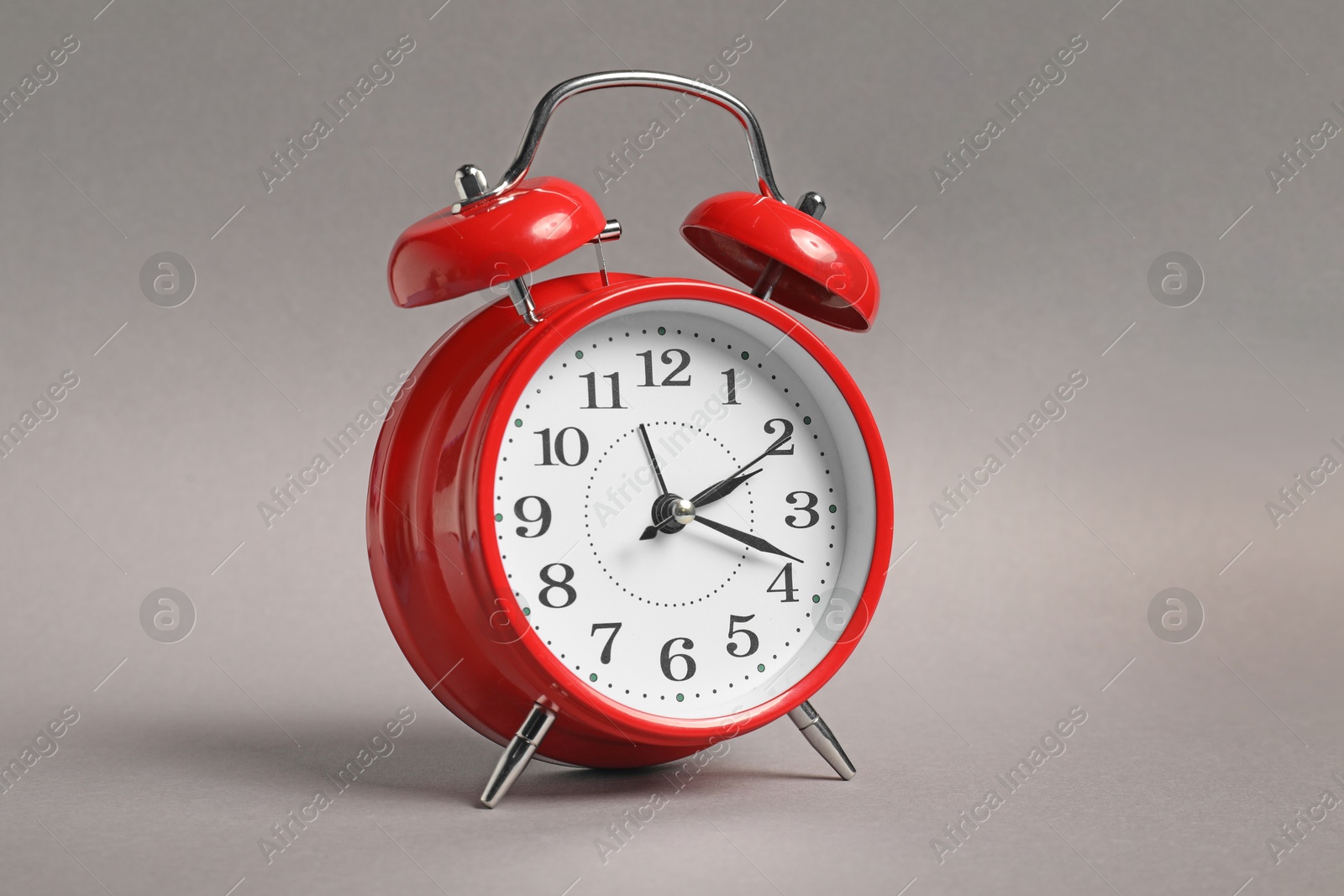 Photo of One red alarm clock on grey background