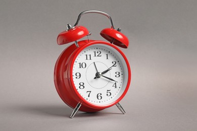 Photo of One red alarm clock on grey background