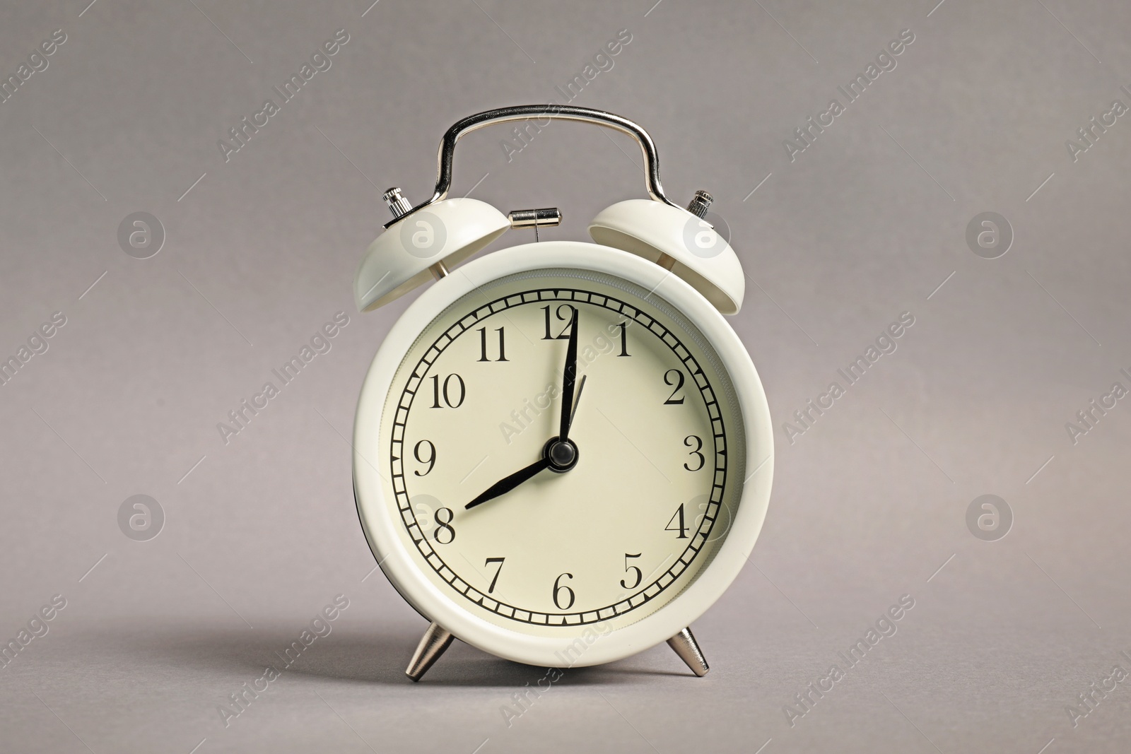 Photo of One white alarm clock on grey background