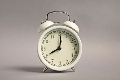 Photo of One white alarm clock on grey background