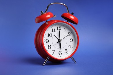 Photo of One red alarm clock on color background