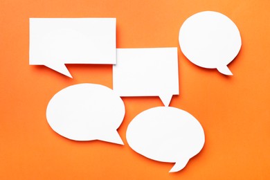 Photo of Blank speech bubbles on orange background, top view. Space for text