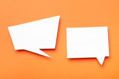 Photo of Blank speech bubbles on orange background, top view. Space for text