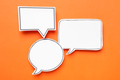 Photo of Blank speech bubbles on orange background, top view. Space for text