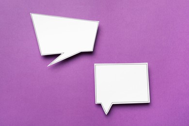 Photo of Blank speech bubbles on purple background, top view. Space for text