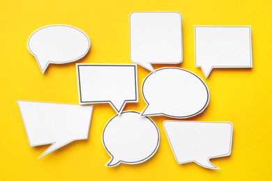 Photo of Blank speech bubbles on yellow background, top view. Space for text