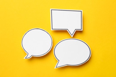 Blank speech bubbles on yellow background, top view. Space for text