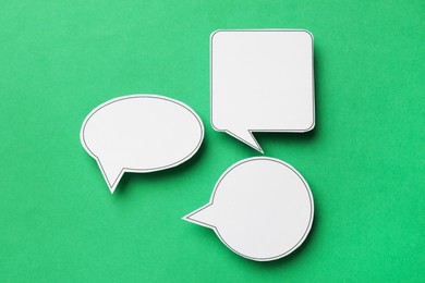 Photo of Blank speech bubbles on green background, top view. Space for text