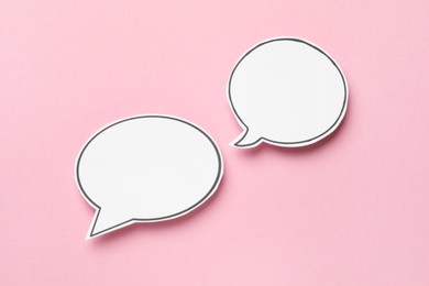 Photo of Blank speech bubbles on light pink background, top view. Space for text