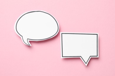 Photo of Blank speech bubbles on light pink background, top view. Space for text