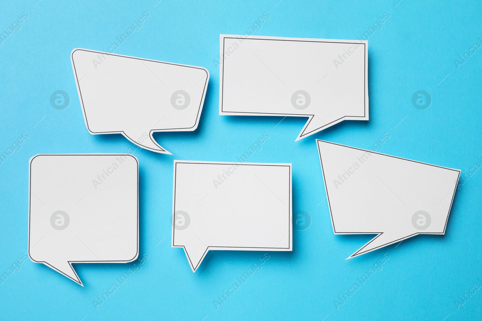 Photo of Blank speech bubbles on light blue background, top view. Space for text