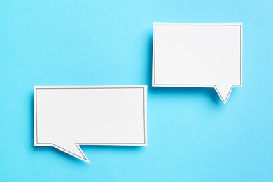 Photo of Blank speech bubbles on light blue background, top view. Space for text