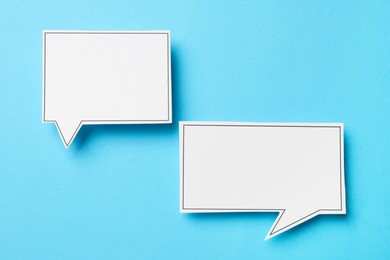 Photo of Blank speech bubbles on light blue background, top view. Space for text