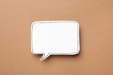 Photo of Blank speech bubble on brown background, top view. Space for text