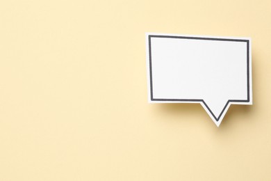 Blank speech bubble on beige background, top view. Space for text