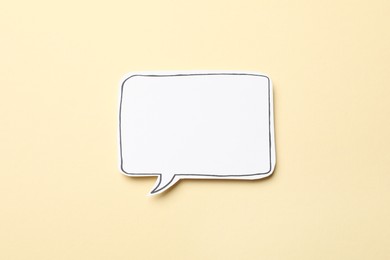 Blank speech bubble on beige background, top view. Space for text