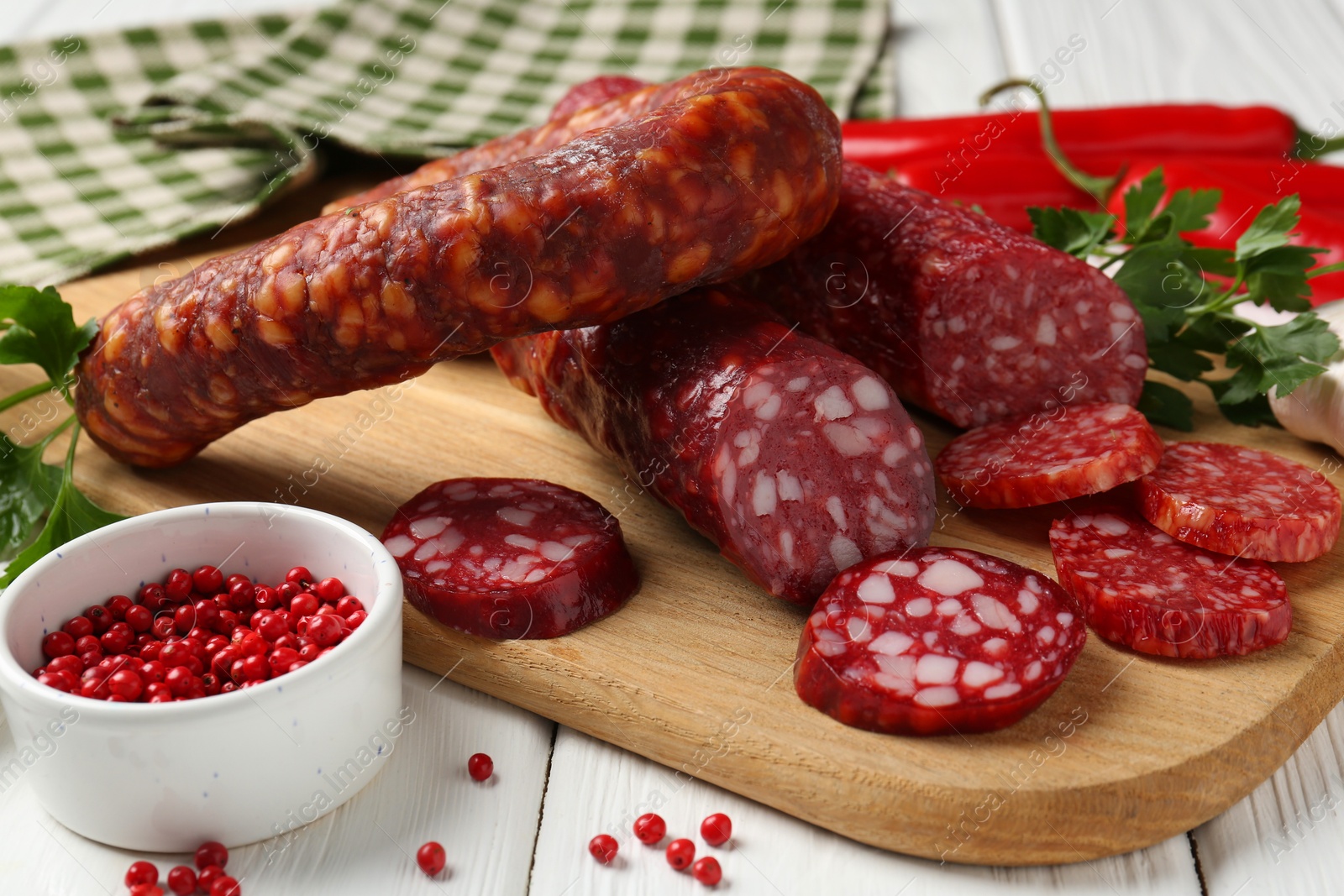 Photo of Different smoked sausages and spices on white wooden table, closeup