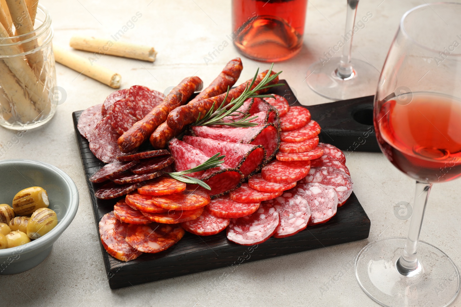 Photo of Different smoked sausages slices served on light table