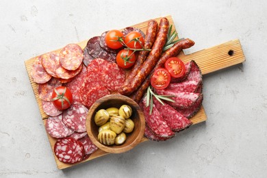 Photo of Different smoked sausages slices served on light table, top view