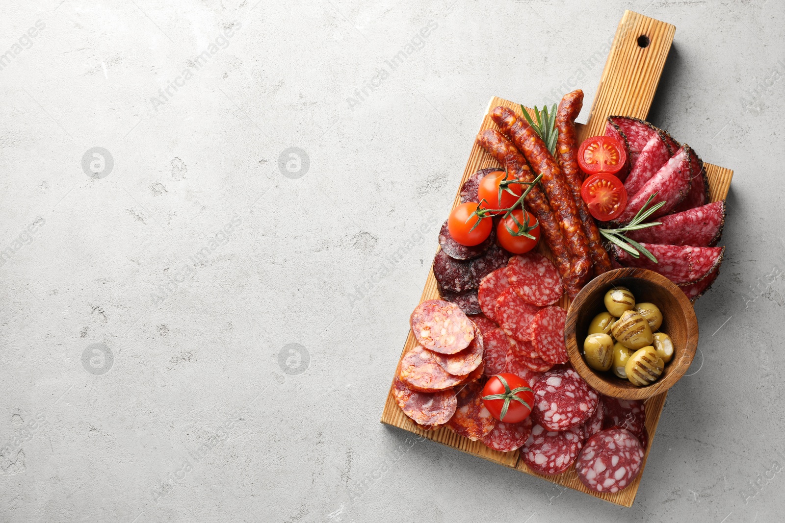 Photo of Different smoked sausages slices served on light table, top view. Space for text