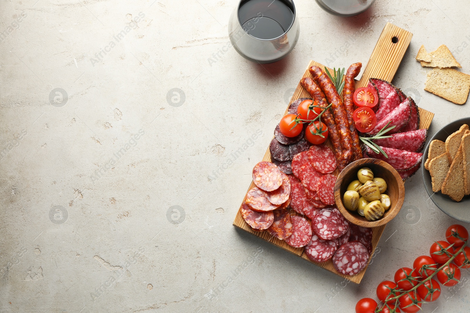 Photo of Different smoked sausages slices served on light table, flat lay. Space for text