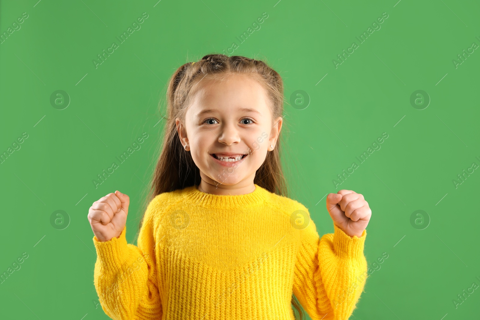 Photo of Portrait of cute little girl with missing tooth on green background