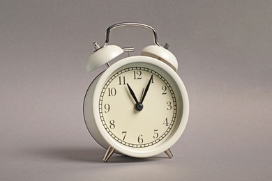 Photo of One white alarm clock on grey background