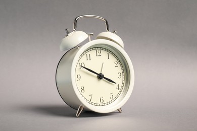 Photo of One white alarm clock on grey background