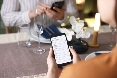 Photo of Couple choosing dishes from digital menu at restaurant, closeup