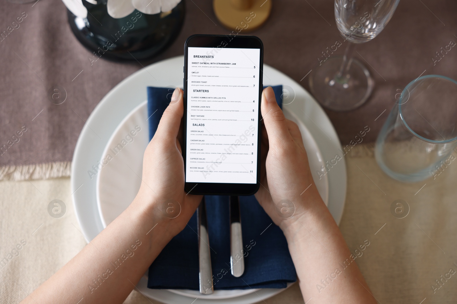 Photo of Woman choosing dish from digital menu at table in restaurant, top view