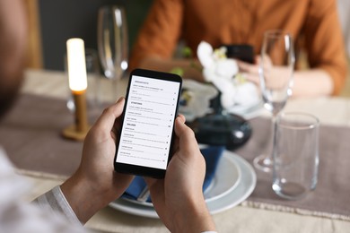 Photo of Couple choosing dishes from digital menu at restaurant, closeup