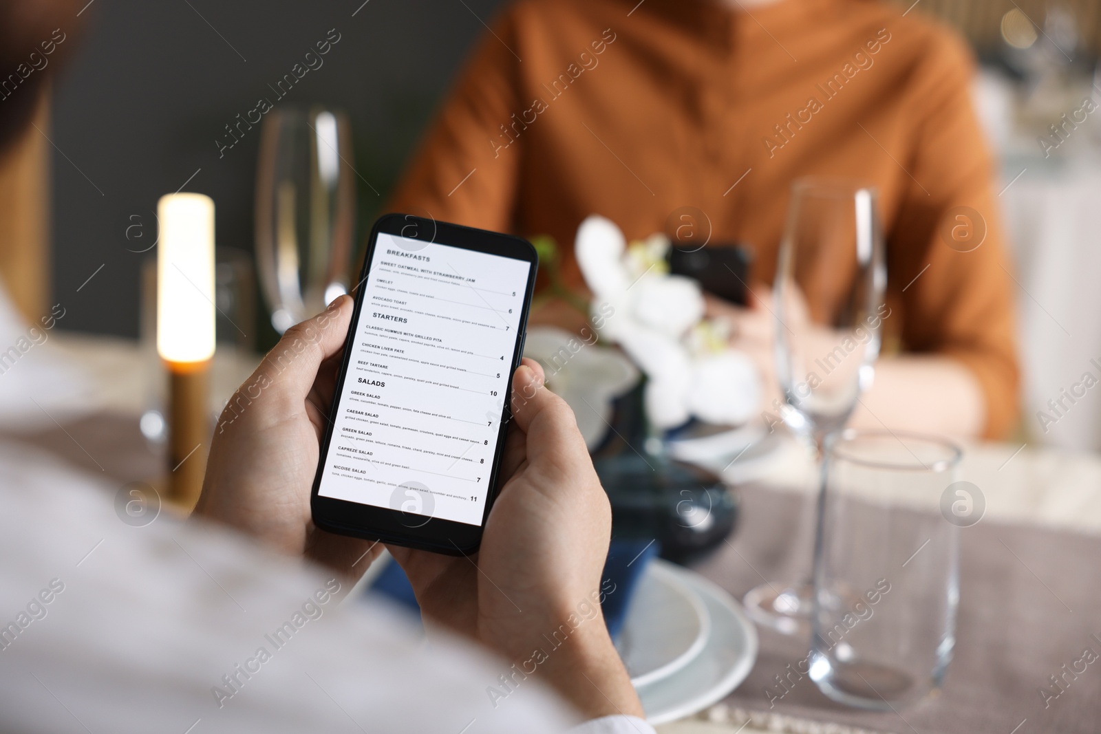 Photo of Couple choosing dishes from digital menu at restaurant, closeup