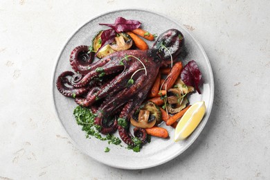 Photo of Roasted octopus with vegetables and mushrooms on light grey table, top view