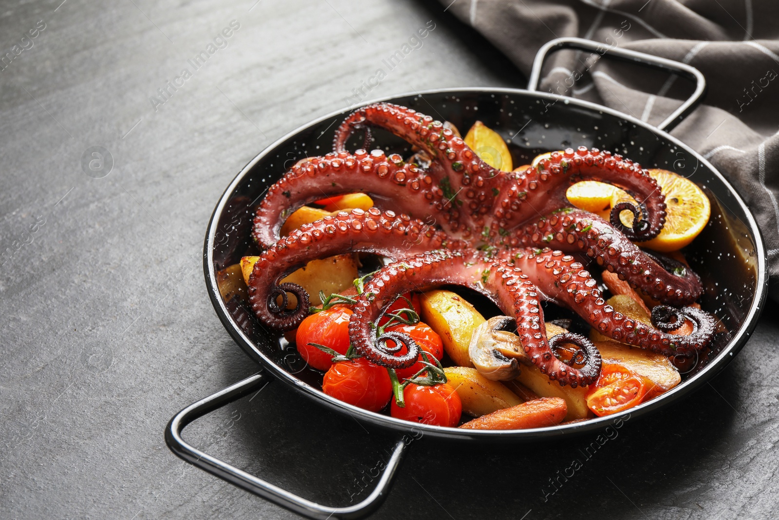 Photo of Fried octopus with mushroom and vegetables on grey textured table, closeup. Space for text