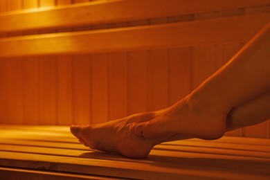 Photo of Young woman relaxing in hot sauna, closeup. Space for text