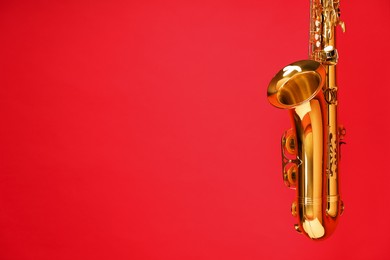 Photo of Jazz. One beautiful saxophone on red background, space for text