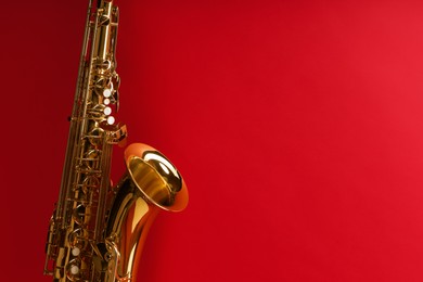 Photo of Jazz. One saxophone on red background, closeup. Space for text