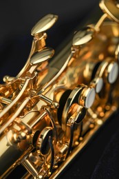 Photo of Jazz. One beautiful saxophone on black background, closeup