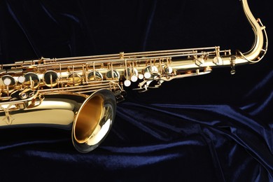 Photo of Jazz. One beautiful saxophone on dark blue fabric