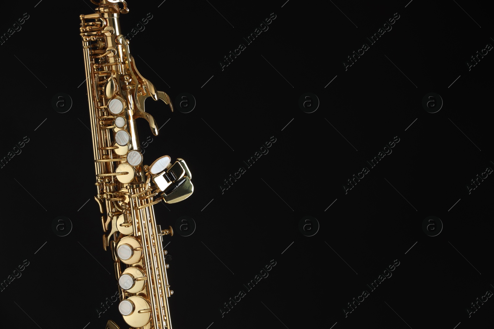 Photo of Jazz. One beautiful saxophone on black background, closeup. Space for text