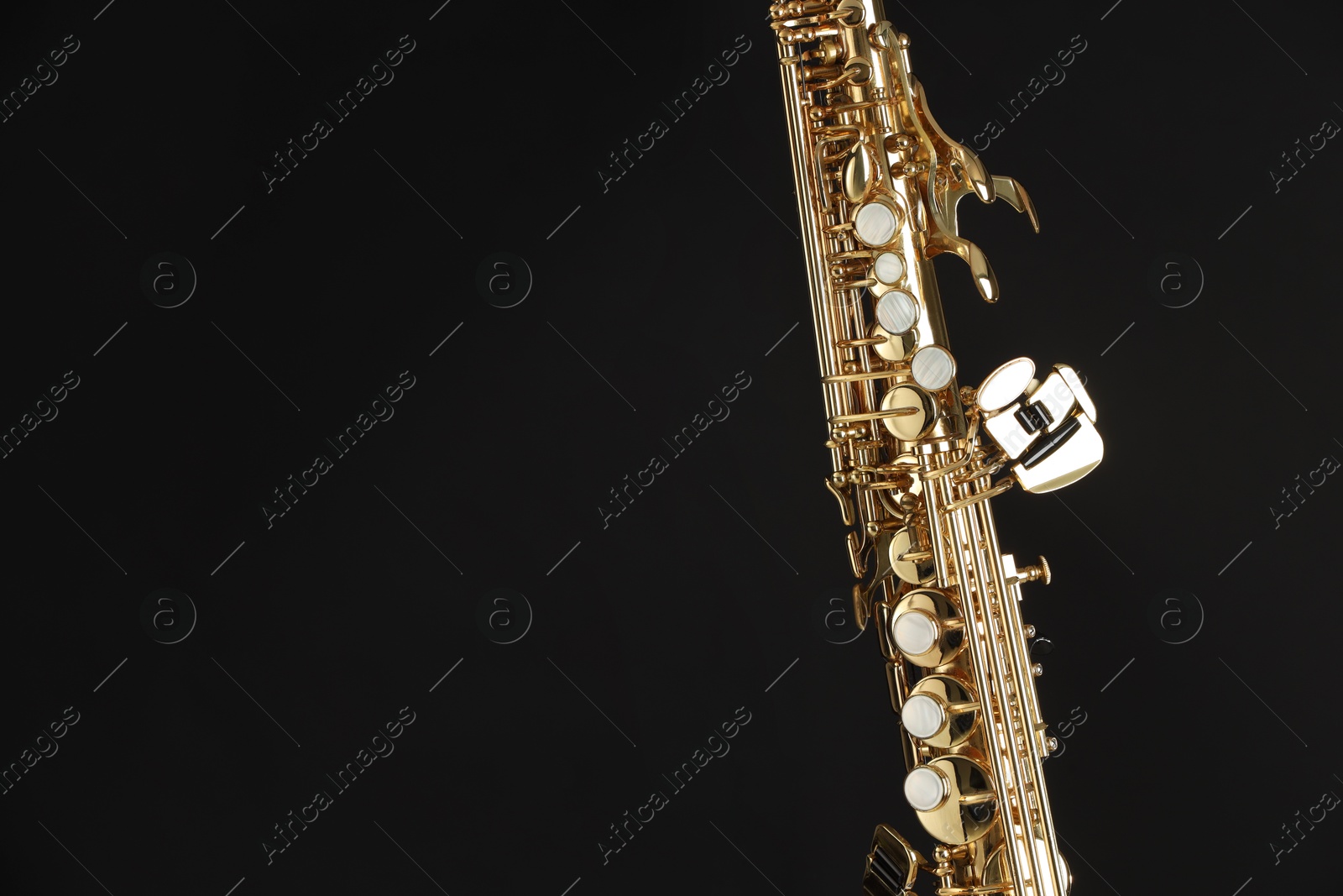 Photo of Jazz. One beautiful saxophone on black background, closeup. Space for text