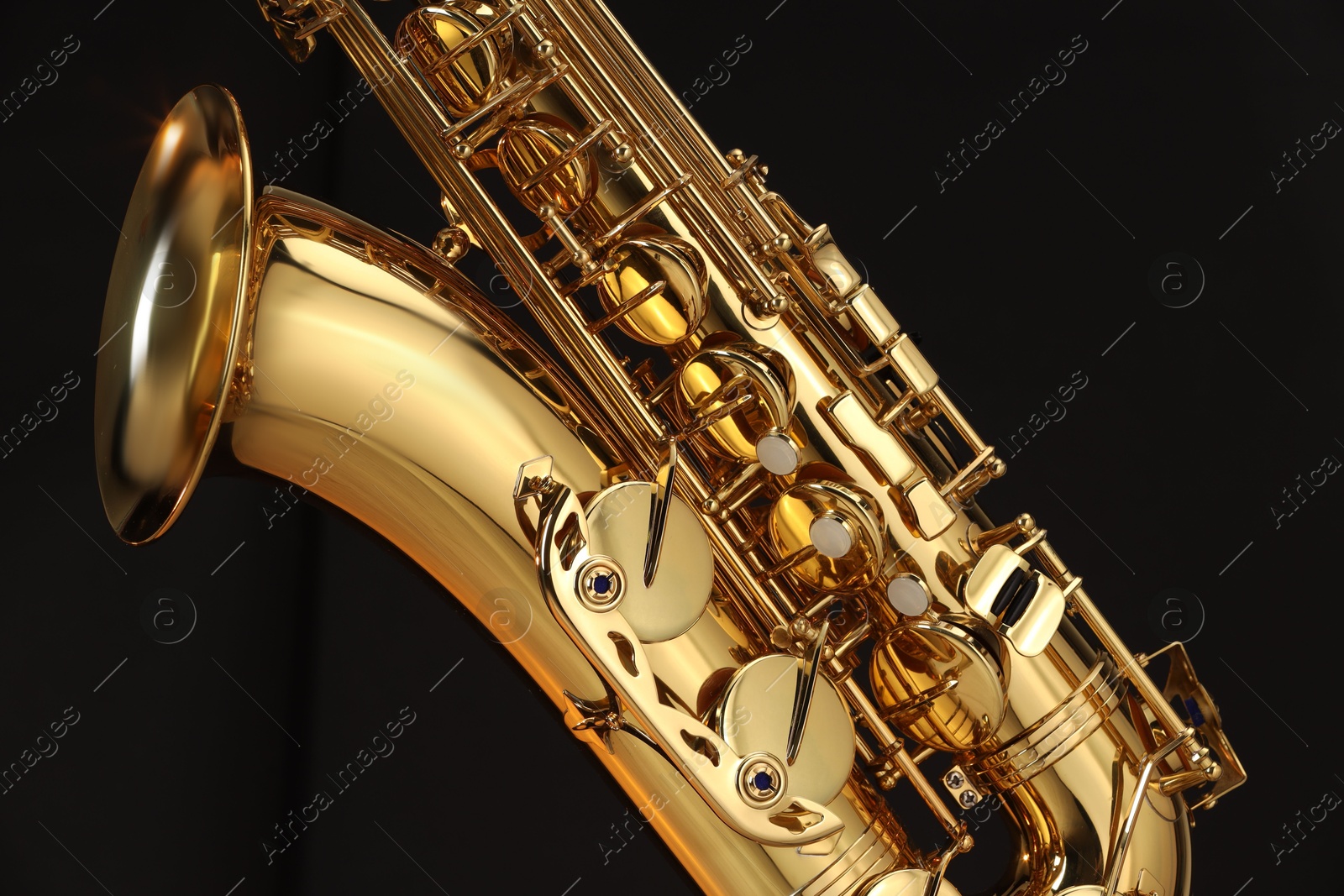 Photo of Jazz. One beautiful saxophone on black background, closeup