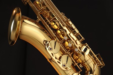 Photo of Jazz. One beautiful saxophone on black background, closeup