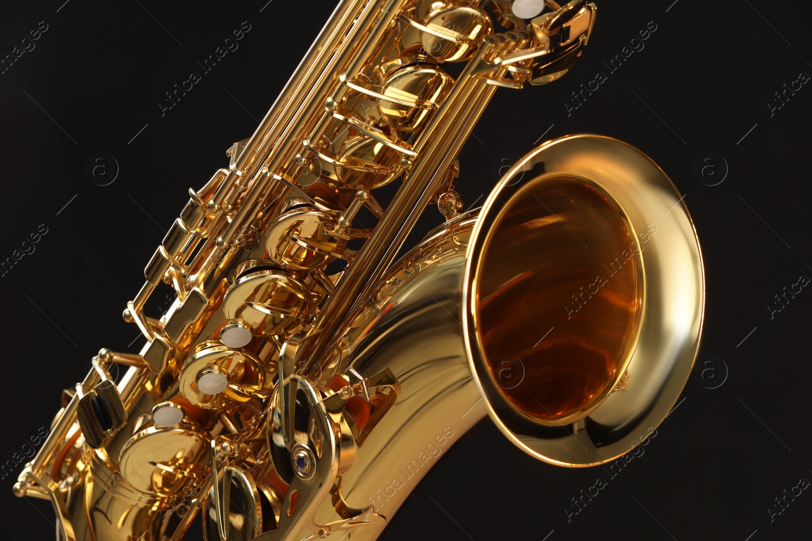 Photo of Jazz. One beautiful saxophone on black background, closeup