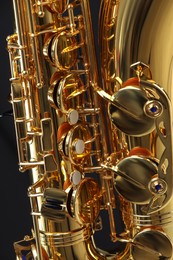 Photo of Jazz. One beautiful saxophone on black background, closeup