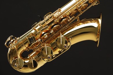 Photo of Jazz. One beautiful saxophone on black background, closeup